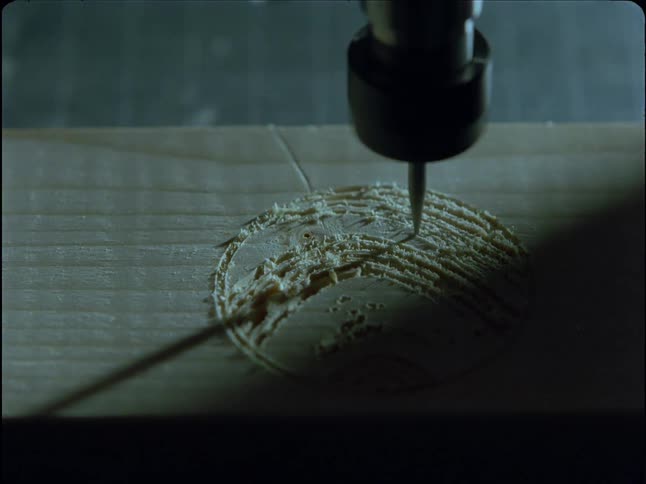 A CNC machine meticulously carves a circular pattern into a wooden surface