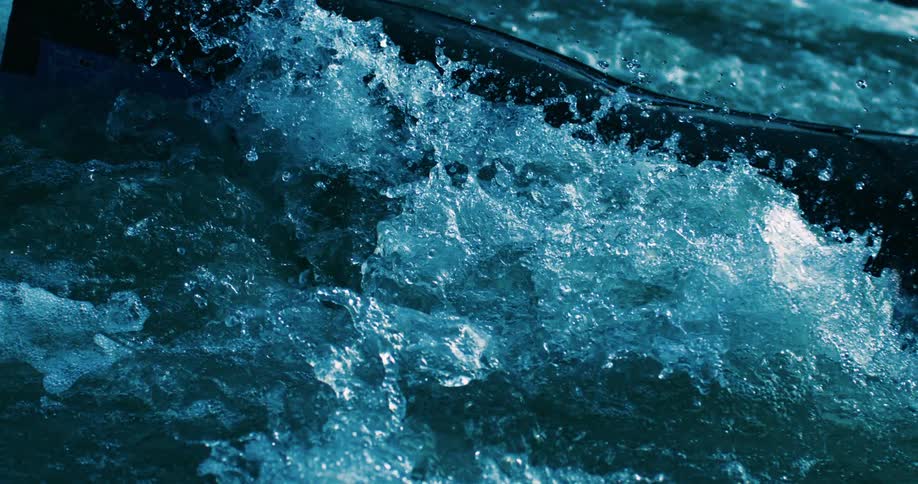 A stunning slow-motion close-up of a kayak navigating turbulent whitewater rapids