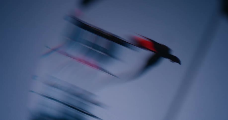 A frantic and chaotic macro shot of a red needle spinning wildly on a dark, blurry mechanical gauge