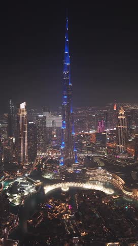 A stunning aerial view of the Burj Khalifa in Dubai at night, illuminated with a dazzling blue light show and a countdown from ten