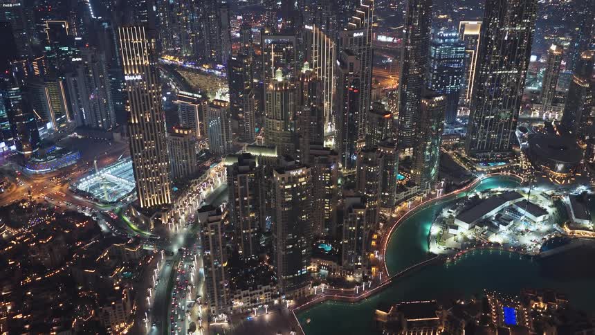 An amazing aerial view of the glittering Dubai cityscape at night, with glowing skyscrapers and a vibrant city life below
