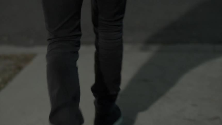 Man walking down a city street at night