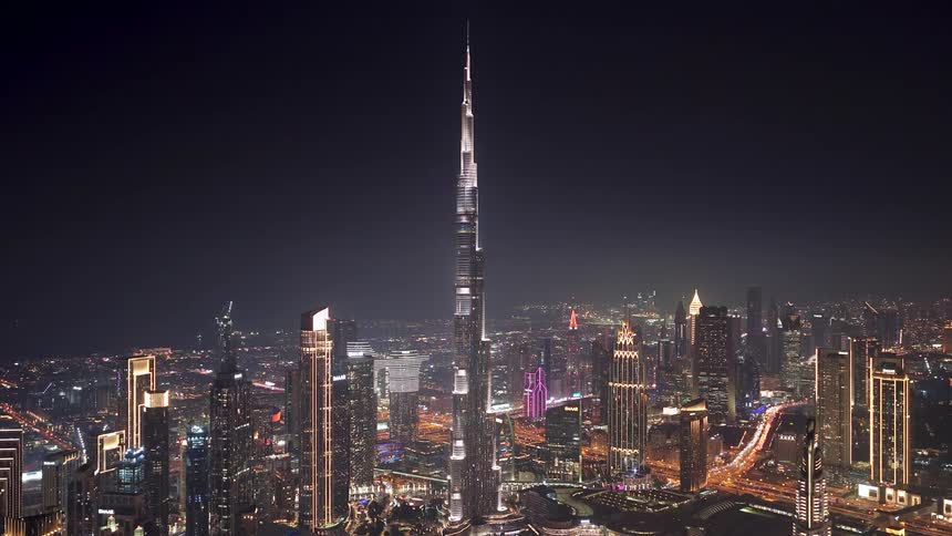 An impressive high-angle view shows the brilliantly lit Burj Khalifa and the sprawling Dubai skyline at night