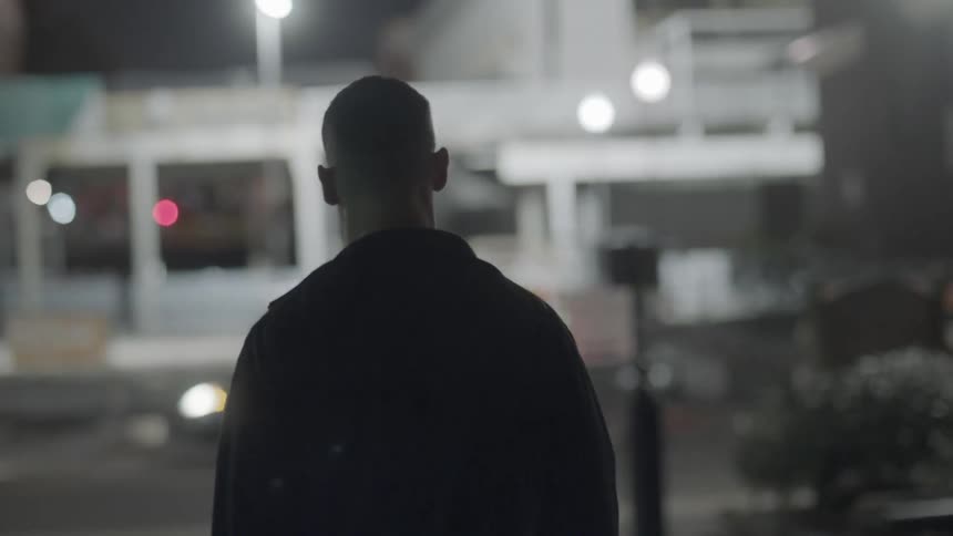 A man walks down the street at night