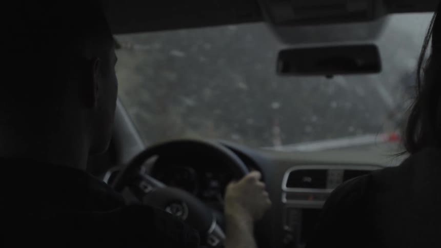 A man drives a car on a snowy day