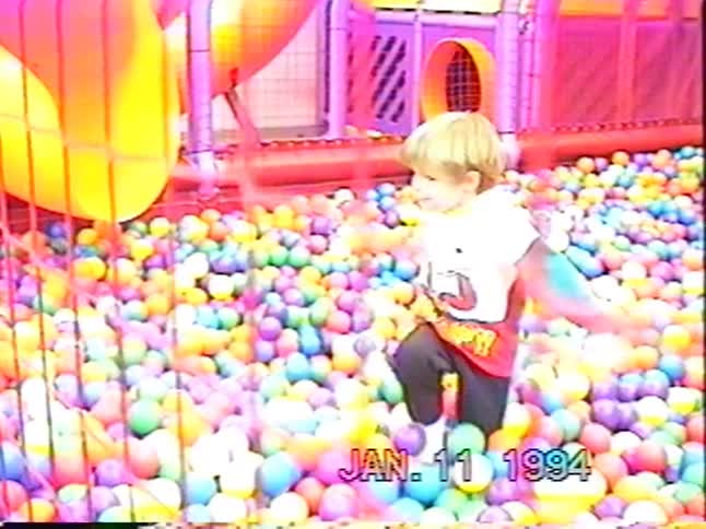 Vintage 1994 home video shows a happy toddler wading through a massive, colorful ball pit at an indoor playground