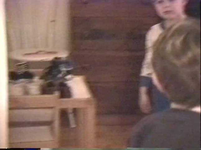 Vintage VHS footage captures two young brothers playing and being silly together in their bedroom