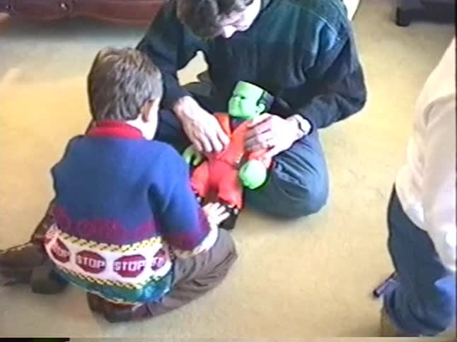 A father and his young son play with a Frankenstein's monster toy in this nostalgic home video from the 90s