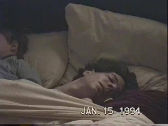 Three young boys sleep soundly together in a bed in this authentic VHS home video from 1994