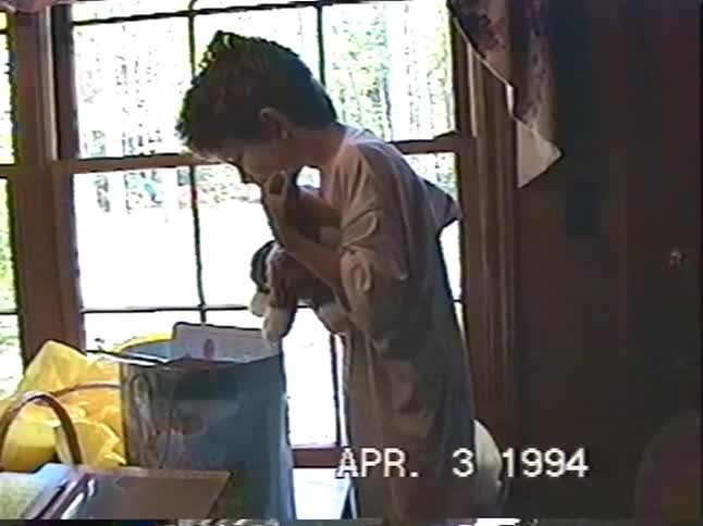 A young boy happily hugs a new stuffed animal on Easter morning in this vintage home video from 1994