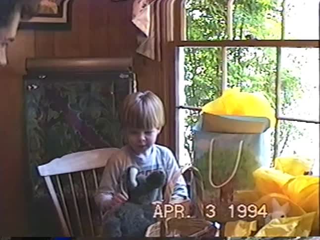 A father gives his excited young son a stuffed bunny rabbit for Easter in a sweet home video from 1994