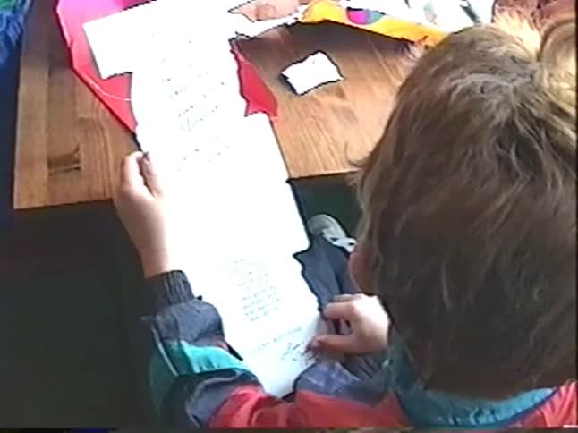 Vintage VHS footage shows a boy reading a baseball-themed birthday card while his younger brother excitedly shows off his new baseball glove