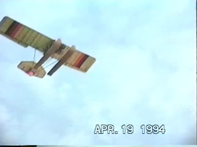 A vintage 1994 home video captures a radio-controlled model airplane flying high in the sky