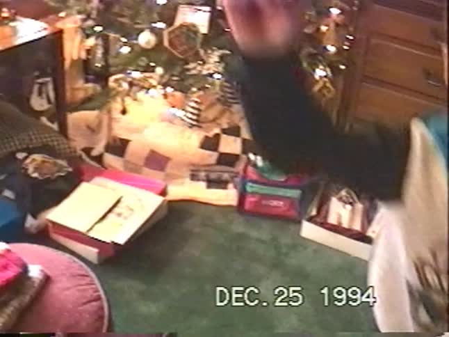 A young boy jumps for joy in front of the Christmas tree on Christmas morning in this 1994 home video