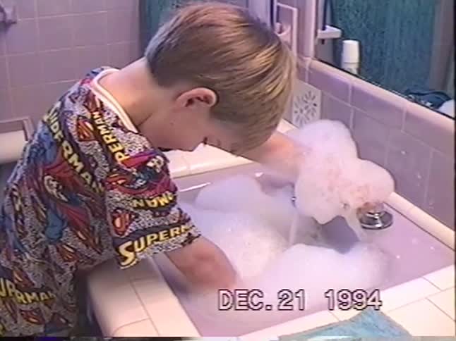 Cute vintage 1994 home video shows a little boy in Superman pajamas making a huge bubble mess in the bathroom sink