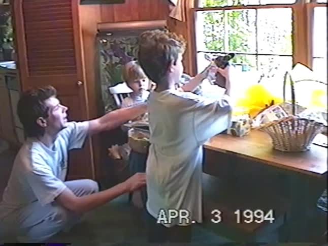 A father and his two young sons play with their new toys and Easter baskets together in a heartwarming 1994 home video