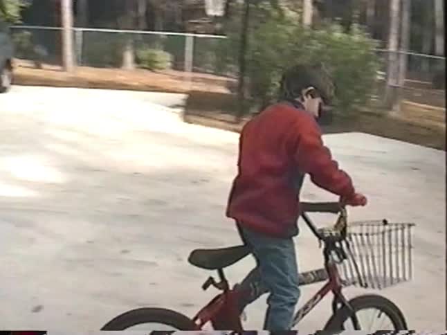 Two young boys joyfully ride their new bicycles around the driveway in this nostalgic home video from the 1990s