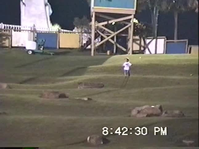 Nostalgic home video footage shows two young boys running around and playing on a mini-golf course at night