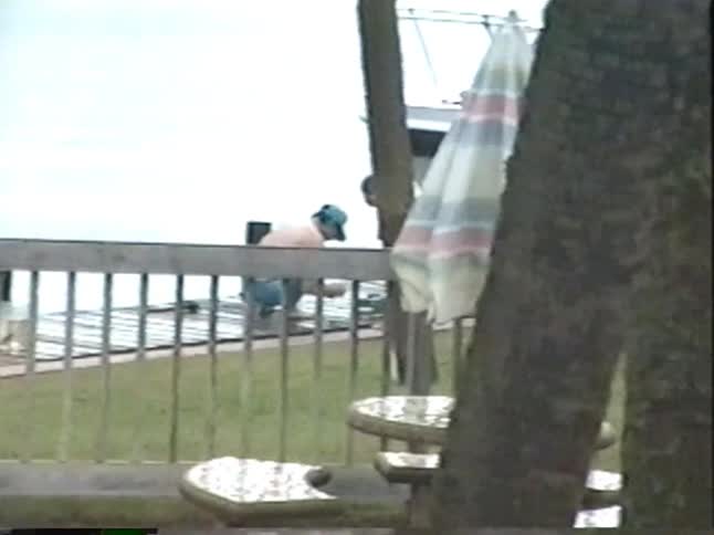 Vintage VHS footage from 1994 shows a young boy playing in the rain and later fishing with his dad on a boat dock