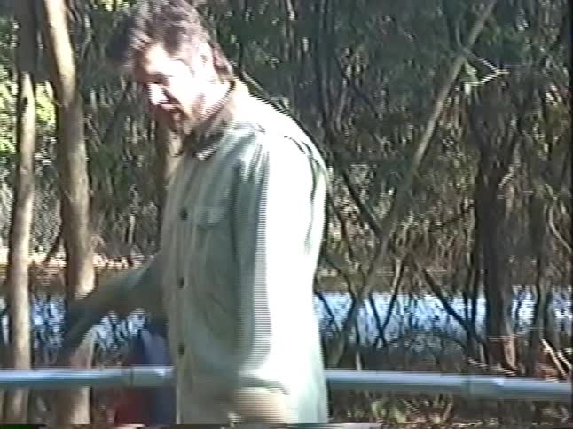 A vintage home video from the 1990s shows a father and his sons on a nature walk in a park by a lake