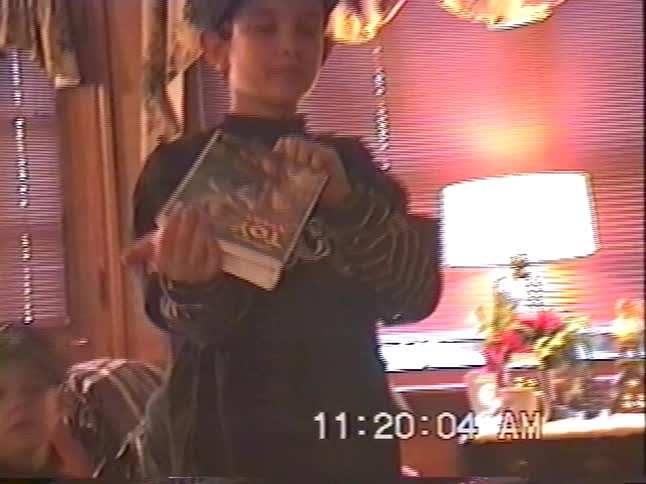 Nostalgic 90s home video captures the excitement of a young boy receiving a "Toy Story" VHS tape on Christmas morning with his family