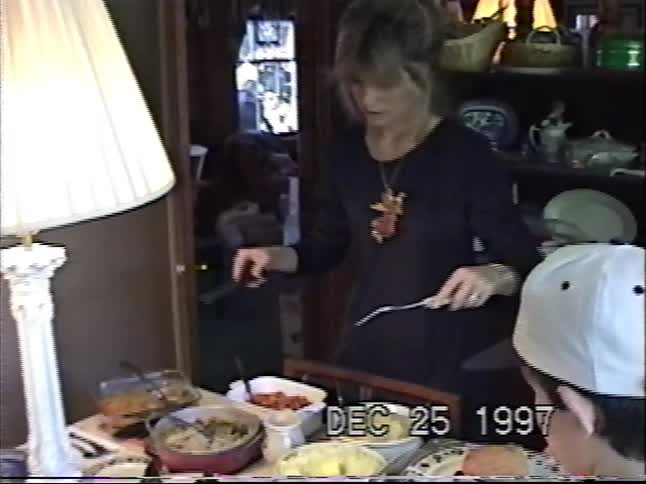 A woman serves a delicious Christmas dinner to her family in this nostalgic VHS home video from 1997
