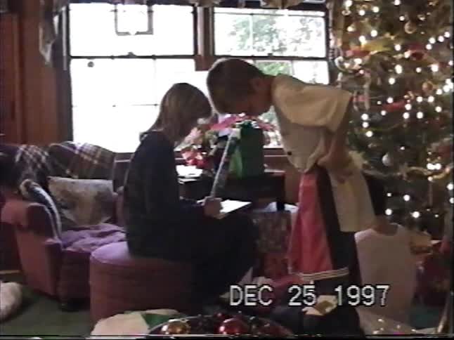Nostalgic home video from 1997 shows siblings opening their Christmas stockings and presents by the tree