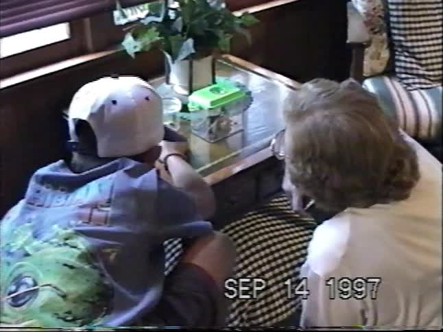 A vintage VHS clip from 1997 shows a young boy proudly showing his grandmother a critter he caught in a bug box