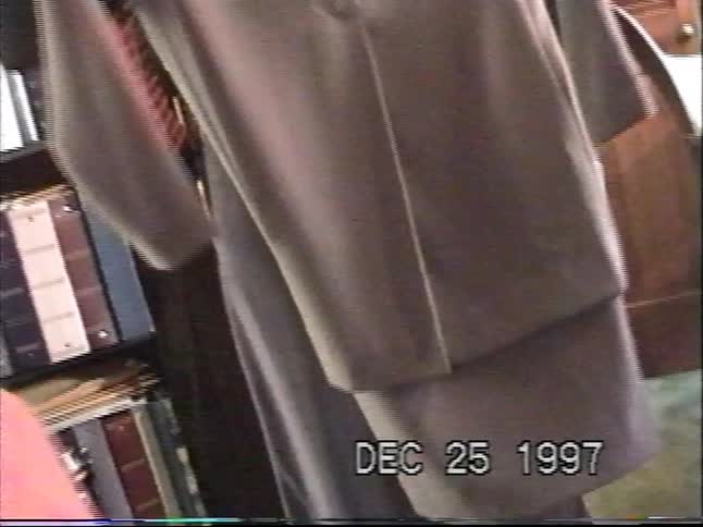 A woman shows off a new clothing outfit she received as a Christmas gift in a 1997 home video
