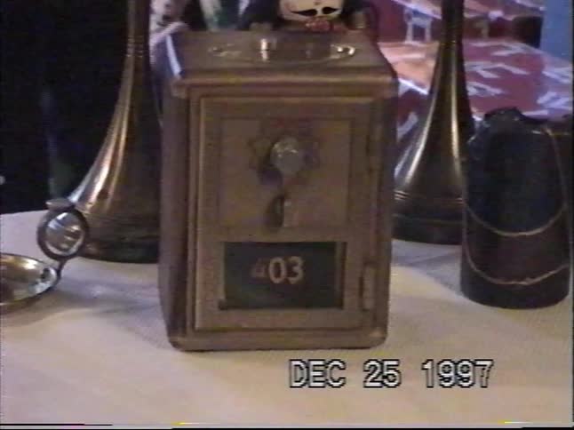 A slow zoom on a vintage P.O. box-style piggy bank on a table with Christmas decorations in the background