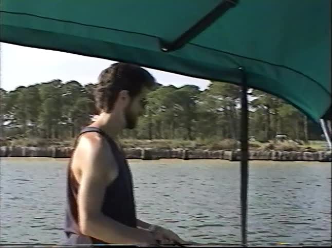 Vintage home video captures a man and a young boy enjoying a fishing trip on a boat