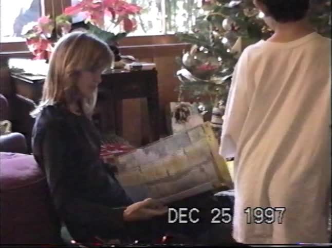 A nostalgic home video from Christmas Day 1997 captures the joy of children opening presents by the tree