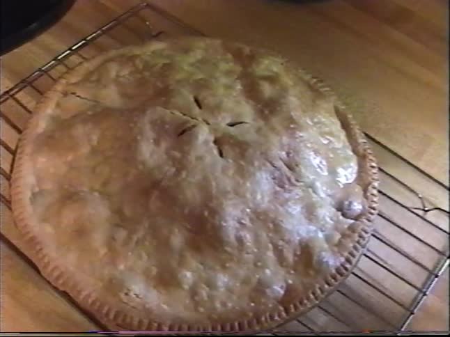 Homemade golden pie cooling on a wire rack in a cozy kitchen countertop scene