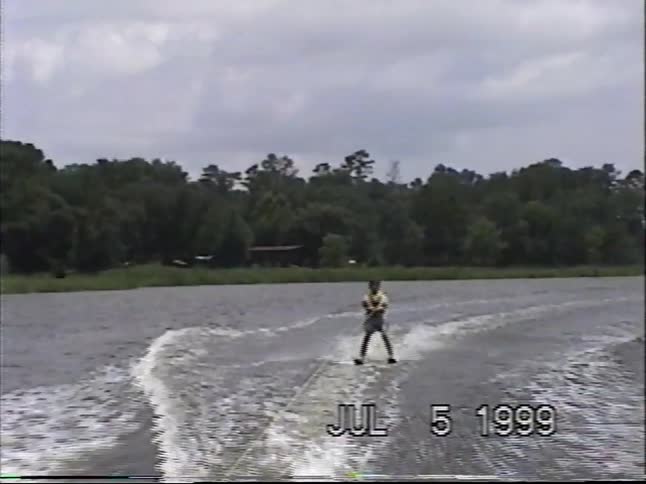 Vintage VHS footage from 1999 shows a water skier enjoying a ride before taking a big splash into the lake