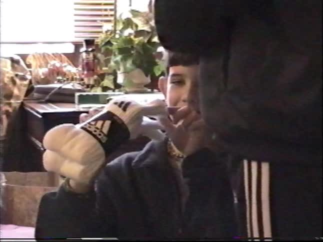 A young boy is thrilled to open a new package of socks on Christmas morning in a nostalgic home video