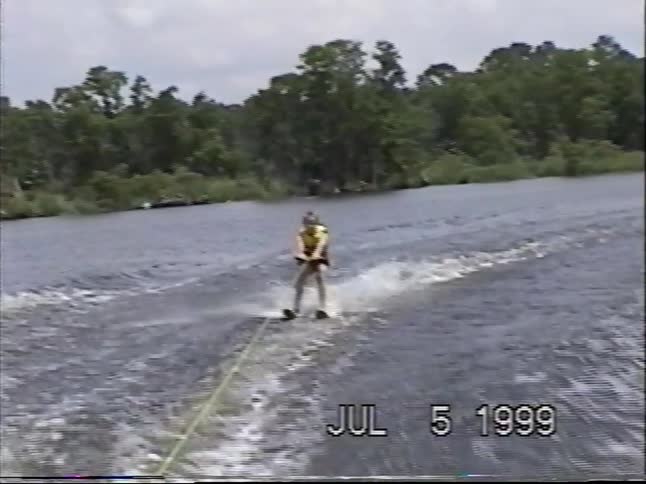Vintage 1999 home movie footage of a young girl successfully water skiing on a lake