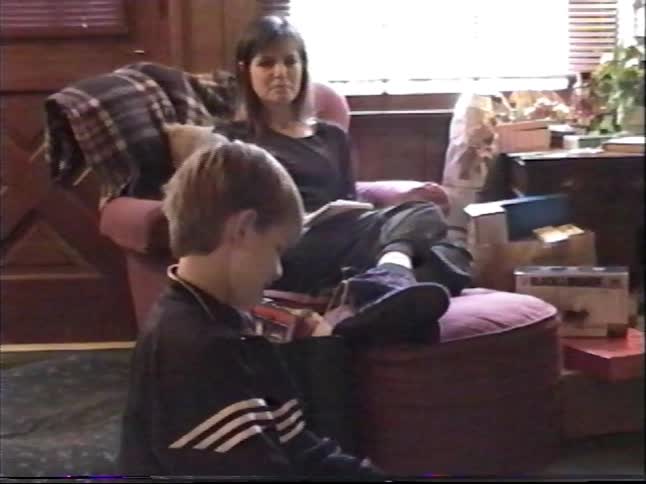 Excited young boy opens a PlayStation console as a Christmas present in a nostalgic home video