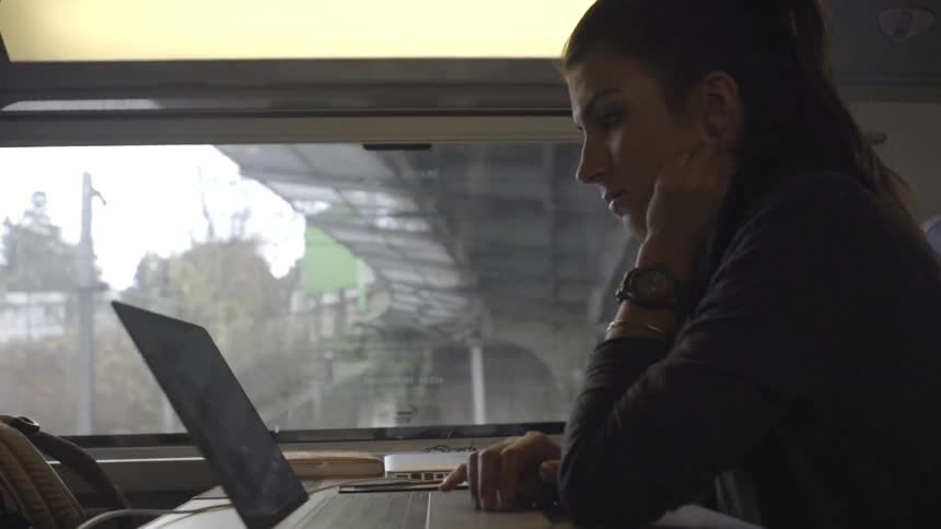 A woman is using a laptop in a train