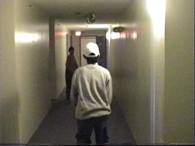 Found footage style video follows two young men as they playfully walk, jump, and dance down a long, monotonous building hallway
