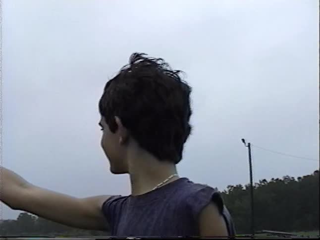 Vintage footage shows a teenage boy checking a rain gauge and running through a flooded area, spooking a flock of seagulls