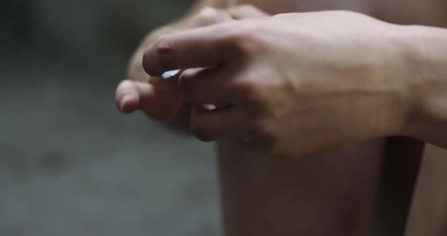 Person wrapping tape around their middle finger outdoors