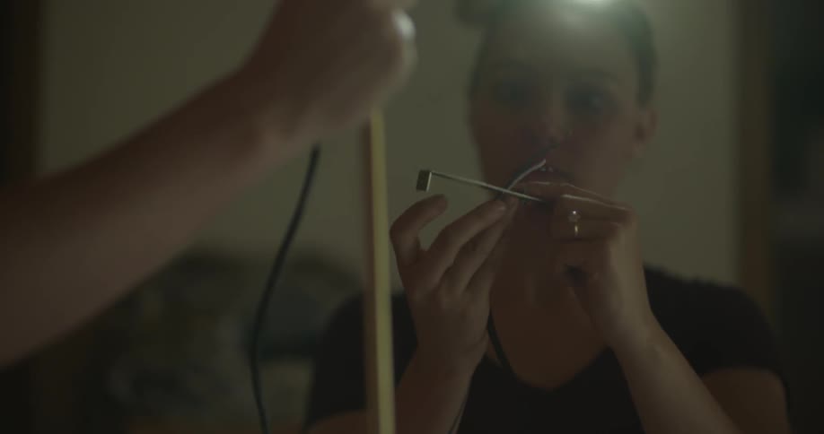 A woman feeds wire through a metal bracket