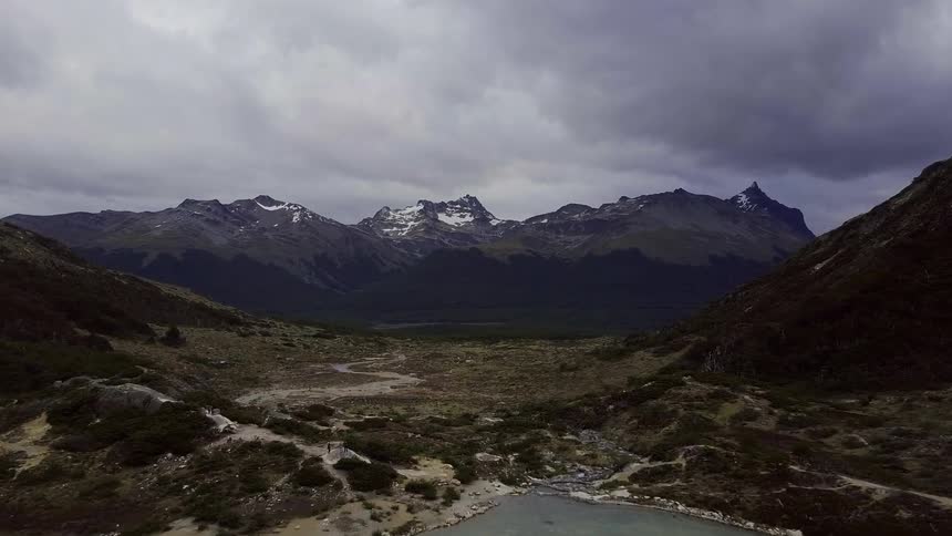 Dark clouds hover over a mountain range and lake