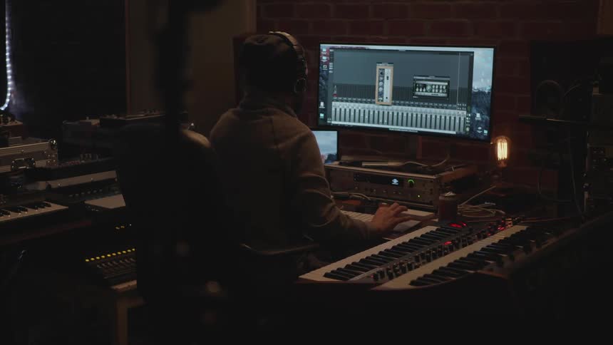 Person sitting in front of a monitor and a control board
