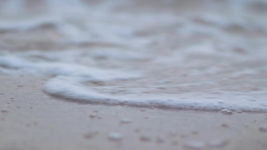 Waves coming ashore and then receding on a beach