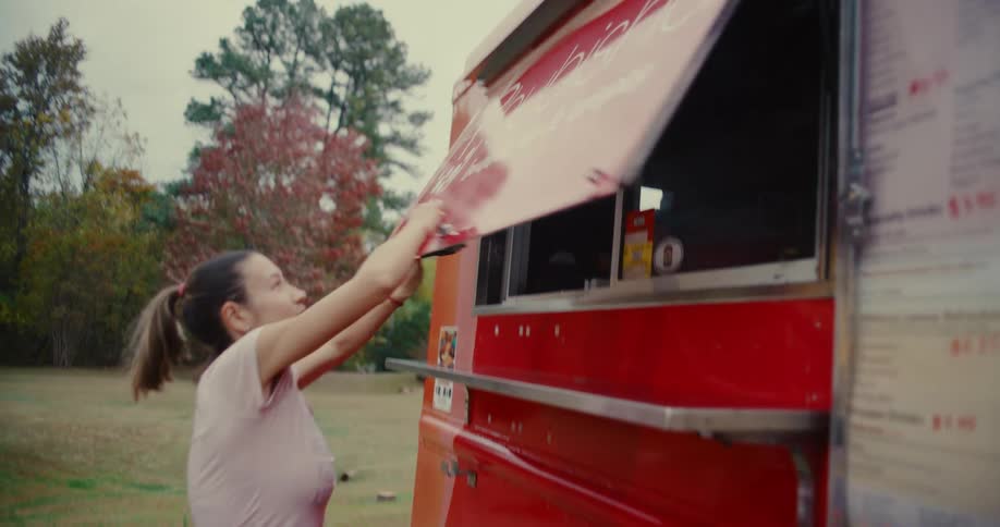 A female food truck owner opens up her bubble tea and crepes truck for a day of business