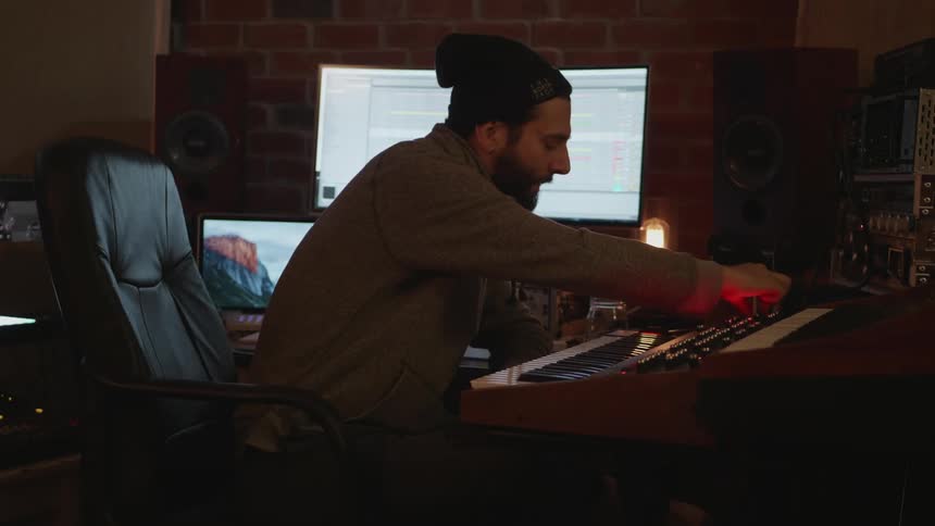A man is adjusting his electronic keyboard