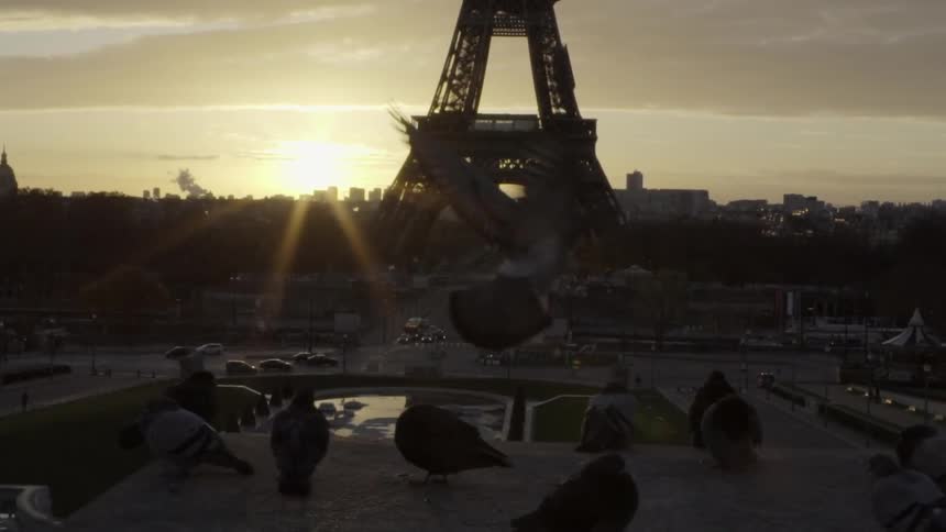 The sun rises behind the eiffel tower