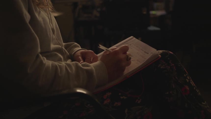 A woman is taking notes in a notebook