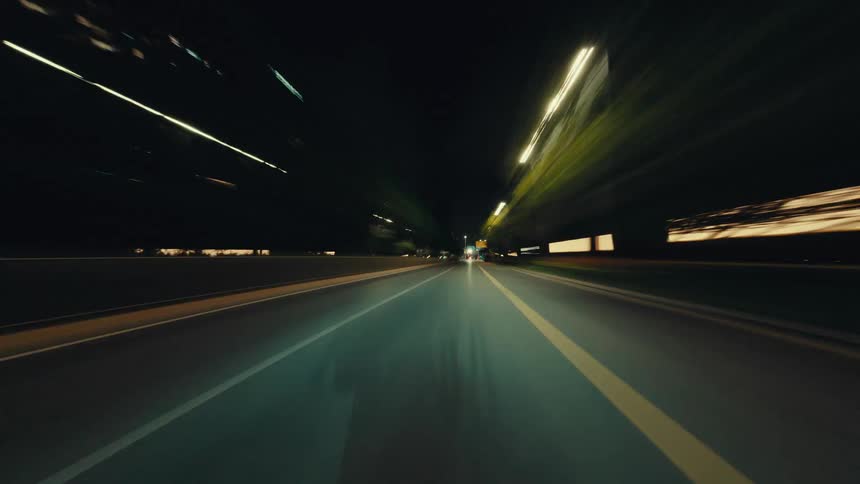 Futuristic POV hyperlapse shows a high-speed journey through a modern city at night with mesmerizing light trails